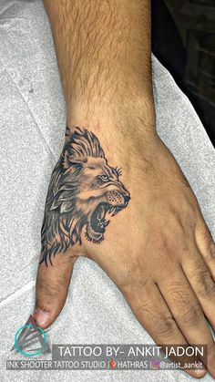 a man's hand with a lion tattoo on it