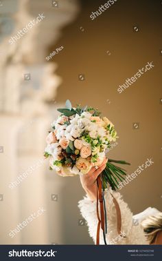 a woman holding a bouquet of flowers in her hand