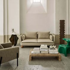 a living room with two couches, a coffee table and a vase on the floor