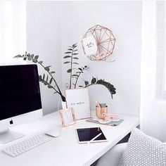 a desk with a computer, tablet and phone on it