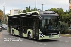 a green and black bus driving down the street