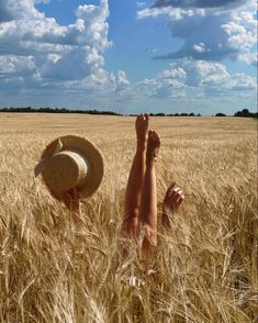 a person laying in the middle of a wheat field with their feet up and arms out