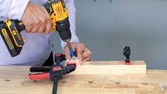 a man is working with tools on a piece of wood