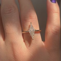 a woman's hand with a diamond ring on it