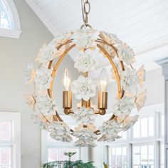 a chandelier hanging from the ceiling in a living room with flowers on it