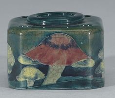 a ceramic jar with an image of a turtle on it's side and two other animals in the background