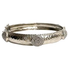 Description Your style comes to life wearing this unique, edgy and timeless sterling silver bracelet. Raised circle appliques totaling 2.20 carats of pave diamonds encircle and embellish this stunning bangle. Artistically hammered by hand to create dazzling reflections when catching the light, it is sure to be a fashion-forward addition to your jewelry wardrobe. Along with its beauty, this hinged bracelet features a discrete and secure clasp. Item # B1203 If you prefer a narrow bangle, see Item Luxury Silver Bracelets With Single Cut Diamonds, Fine Jewelry Sterling Silver Hand-set Bangle, Fine Jewelry Sterling Silver Hand Set Bangle, Hand-set Sterling Silver Bangle In Fine Jewelry Style, Fine Jewelry Sterling Silver Bangle Hand Set, Dazzling Sterling Silver Diamond Bangle Bracelet, Luxury Sterling Silver Diamond Bangle Bracelet, Luxury Sterling Silver Bangle Diamond Bracelet, Hammered Round Bracelets For Formal Occasions