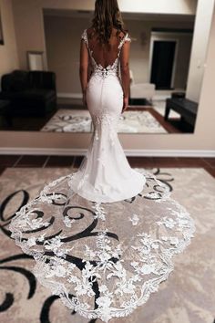 a woman in a wedding dress standing on a rug