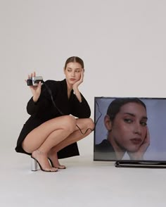 a woman kneeling down next to a television