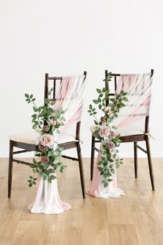 two chairs decorated with flowers and greenery