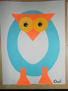 an owl made out of paper sitting on top of a white sheet with blue and orange circles