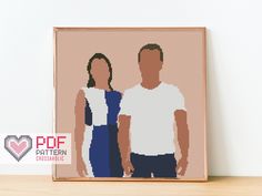 a cross stitch picture of two people standing next to each other in front of a white wall