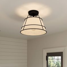 a light fixture hanging from the ceiling in a room with white walls and wood paneling