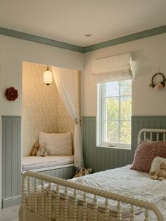 a white bed sitting in a bedroom next to a window