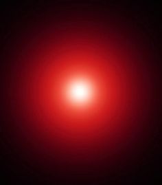 an image of a red light in the middle of dark space with only one light visible