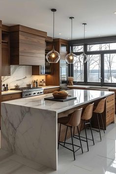 a large kitchen with marble counter tops and wooden cabinets, along with modern lighting fixtures