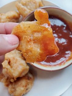 someone is dipping sauce on some fried food