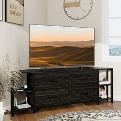 a flat screen tv sitting on top of a wooden dresser