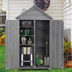 an outdoor storage shed with gardening tools in it