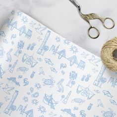 a pair of scissors and twine on top of a paper with blue doodles