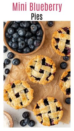 mini blueberry pies on parchment paper with fresh blueberries in the background and text overlay that reads mini blueberry pies