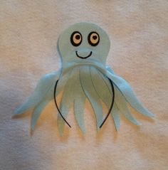 an octopus made out of toilet paper on top of a white towel with black eyes