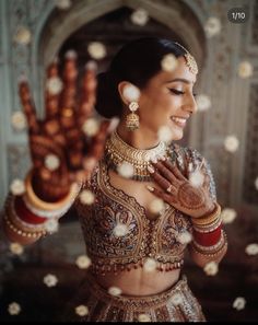 a woman in a bridal outfit holding her hands up