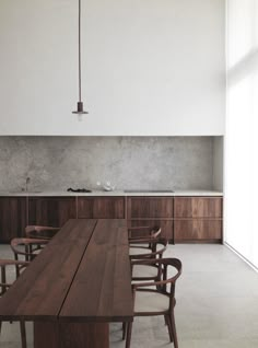 an empty kitchen with chairs and a table in front of the counter top is shown