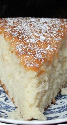 a piece of cake sitting on top of a blue and white plate with powdered sugar