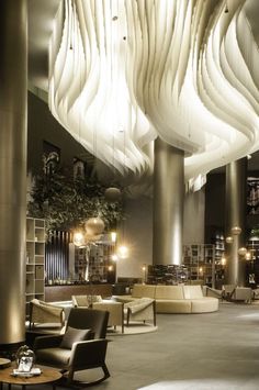 the interior of a modern hotel lobby with high ceilings and large chandeliers hanging from the ceiling