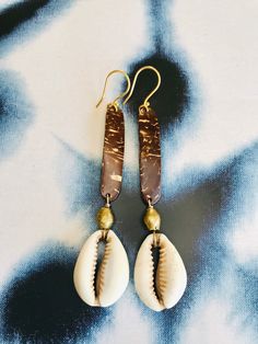 Blessings from divine messengers. These are made from coconut, brass and vintage cowrie shells from Burkina Faso. The are on gold fill hooks. Both the coconut and the cowrie shell are used in divination to communicate messages from Spirit. May these assist you in receiving what is for you.  Cowrie shells have been used around the world for adornment, currency and divination. They symbolize creation, abundance, protection, ancestors. They are considered the mouth of the gods, tools for communicat Handmade Brown Cowrie Shell Jewelry, Bohemian Brown Cowrie Shell Jewelry, Handmade Copper Jewelry For The Beach, Handmade Copper Jewelry For Beach, Artisan Gold Beach Jewelry, Artisan Gold Jewelry For The Beach, Artisan Gold Jewelry For Beach, Artisan Gold Earrings For Beach, Vintage Gold Earrings For Beach