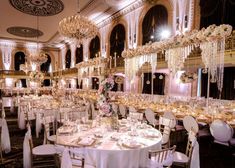 a banquet hall with tables and chairs set up for an event or wedding reception, decorated with chandeliers and floral centerpieces