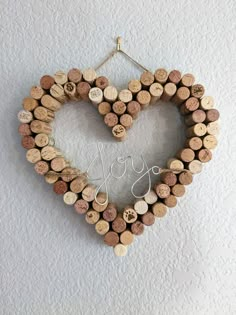 a heart shaped wreath made out of wine corks with the word love spelled on it