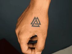 a hand with a triangle tattoo on it