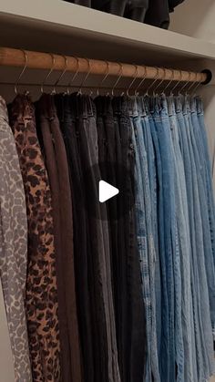 a closet filled with lots of different types of jeans and pants hanging on clothes racks