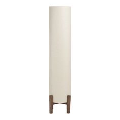 a tall white vase sitting on top of a wooden stand