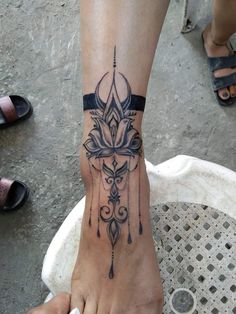 a woman's foot with a tattoo on it and a cross in the middle