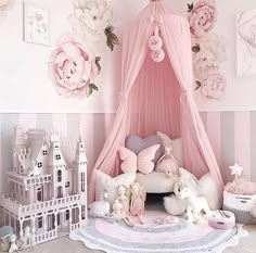 there is a pink canopy bed with flowers on the wall and stuffed animals in front of it