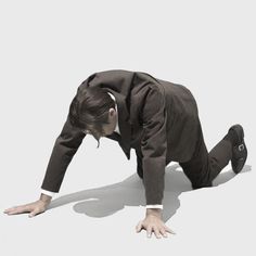 a man in a suit and tie is bending over