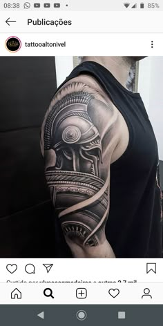 a man with a black and grey tattoo on his arm that has an image of a helmet