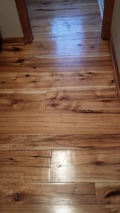 an empty hallway with hard wood floors and white walls