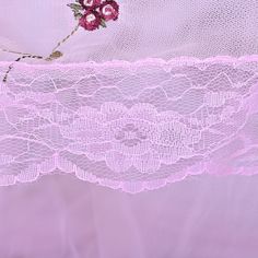 a pink lace curtain with flowers on it