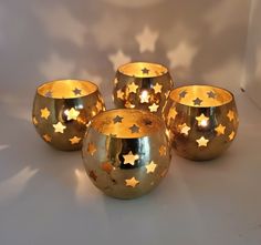 three gold stars are on the top of four small bowls, each with different shapes and sizes