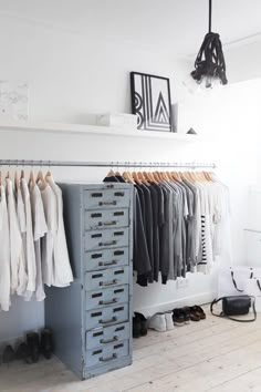 an organized closet with clothes and shoes on hangers