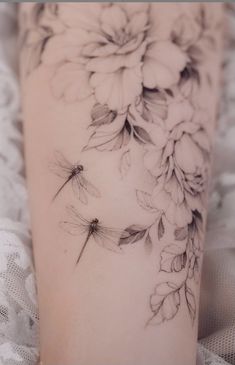 a woman's leg with flowers and dragonflies on it