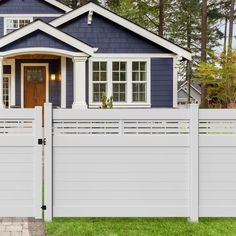 a blue house with white picket fence in the front yard