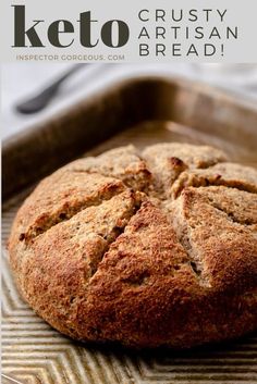 a close up of a loaf of bread on a pan with the words keto crusty artisan bread