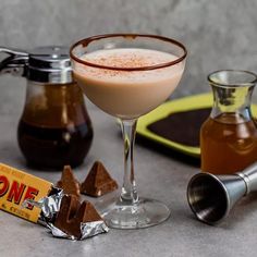 a glass filled with liquid next to some chocolate