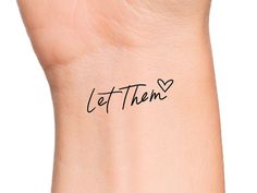 a woman's wrist with the word let them written in cursive font