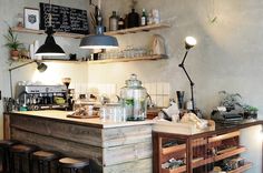 a kitchen with lots of counter space and hanging lights above the bar area, along with stools